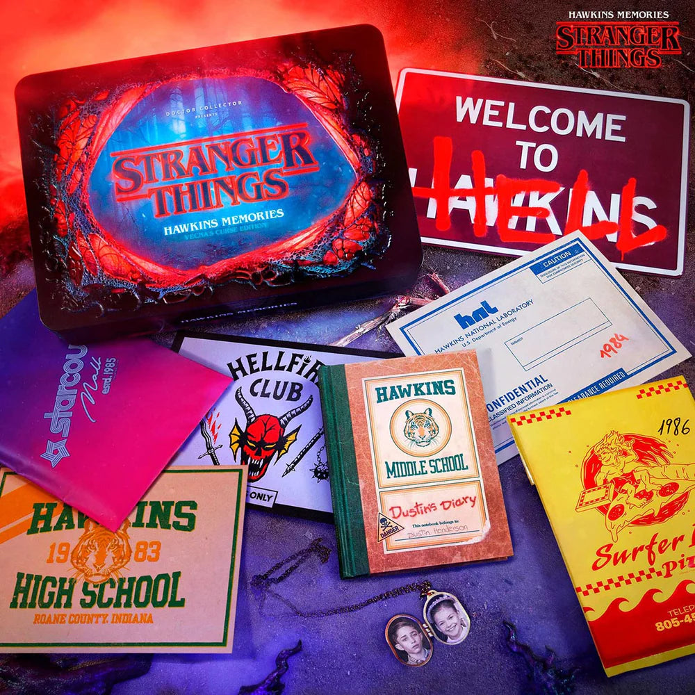 Collection of 'Stranger Things' themed items including a laptop, signs, and memorabilia on a dark surface with red lighting.