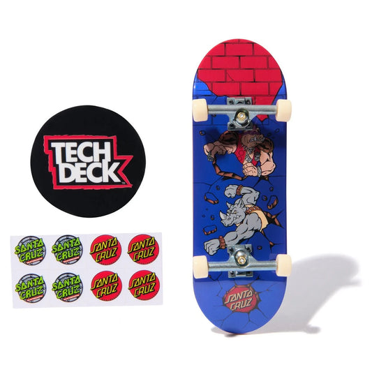 Skateboard deck with cartoon design featuring Road Hogs from TMNT and Santa Cruz branding, accompanied by a Tech Deck logo and stickers.
