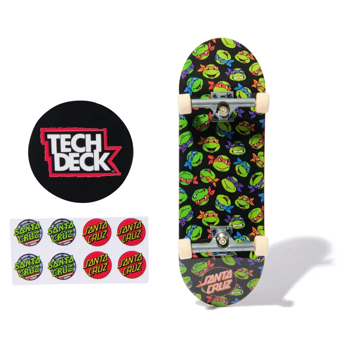Skateboard deck with Teenage Mutant Ninja Turtles design, Tech Deck logo, and Santa Cruz stickers on a white background