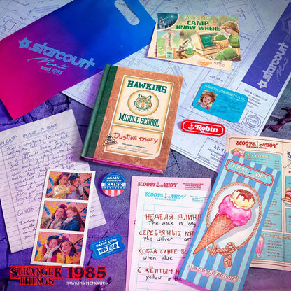 Collection of 'Stranger Things' themed items including a diary, postcards, and promotional materials on a textured surface.